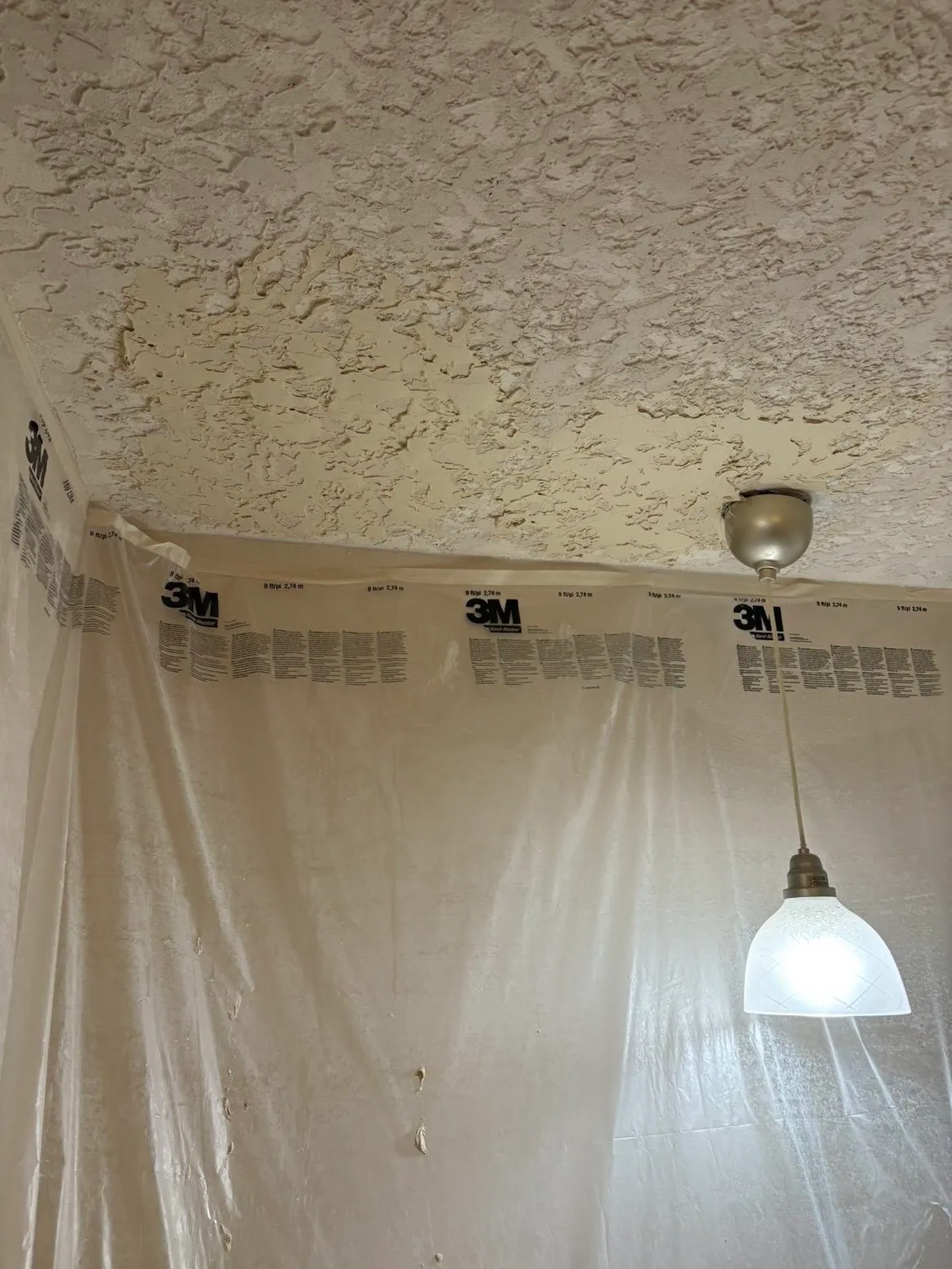 Two kitchen ceiling patches near a light fixture with texture matched seamlessly