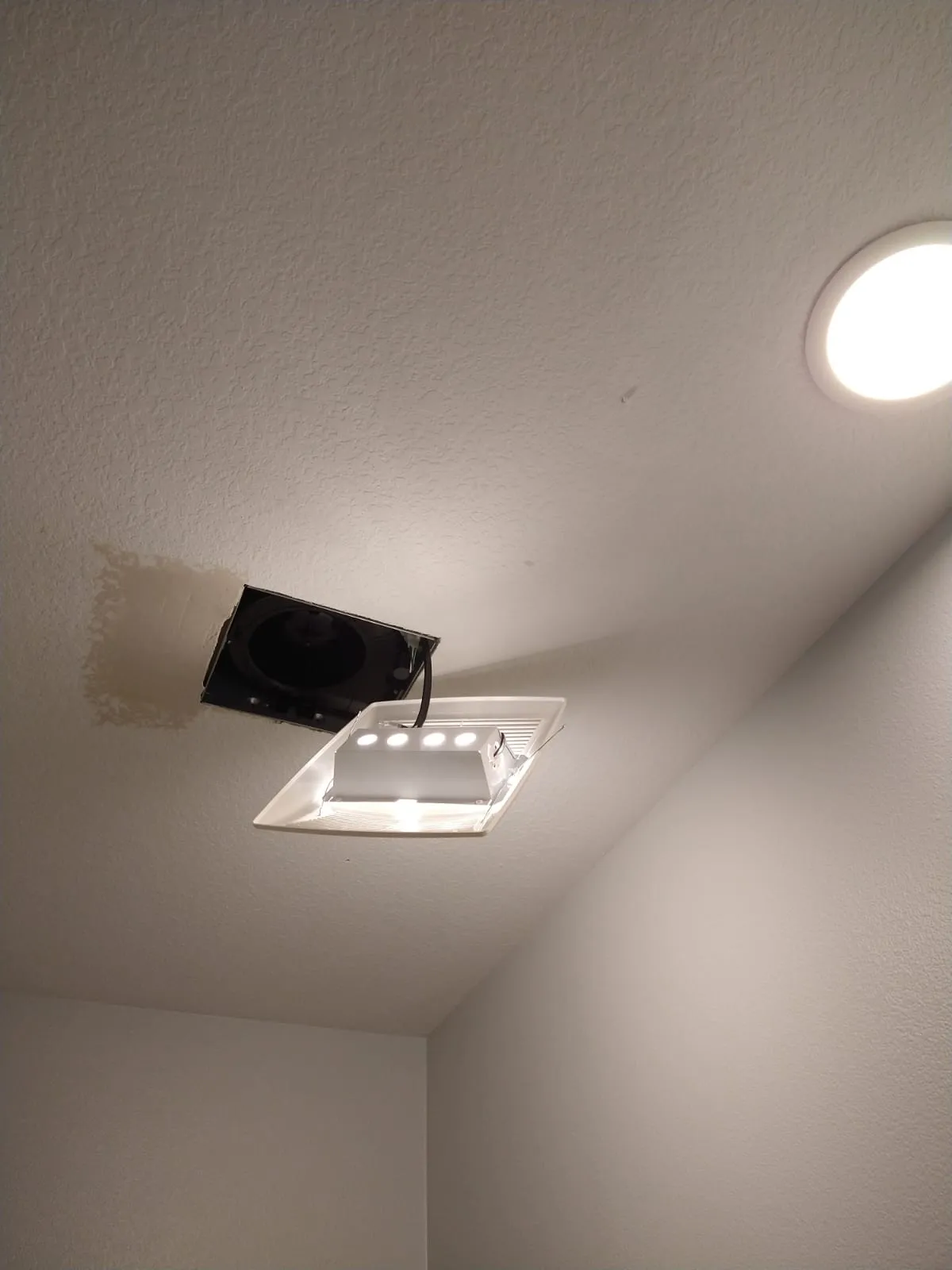 Ceiling drywall repair around light fixture with smooth finish