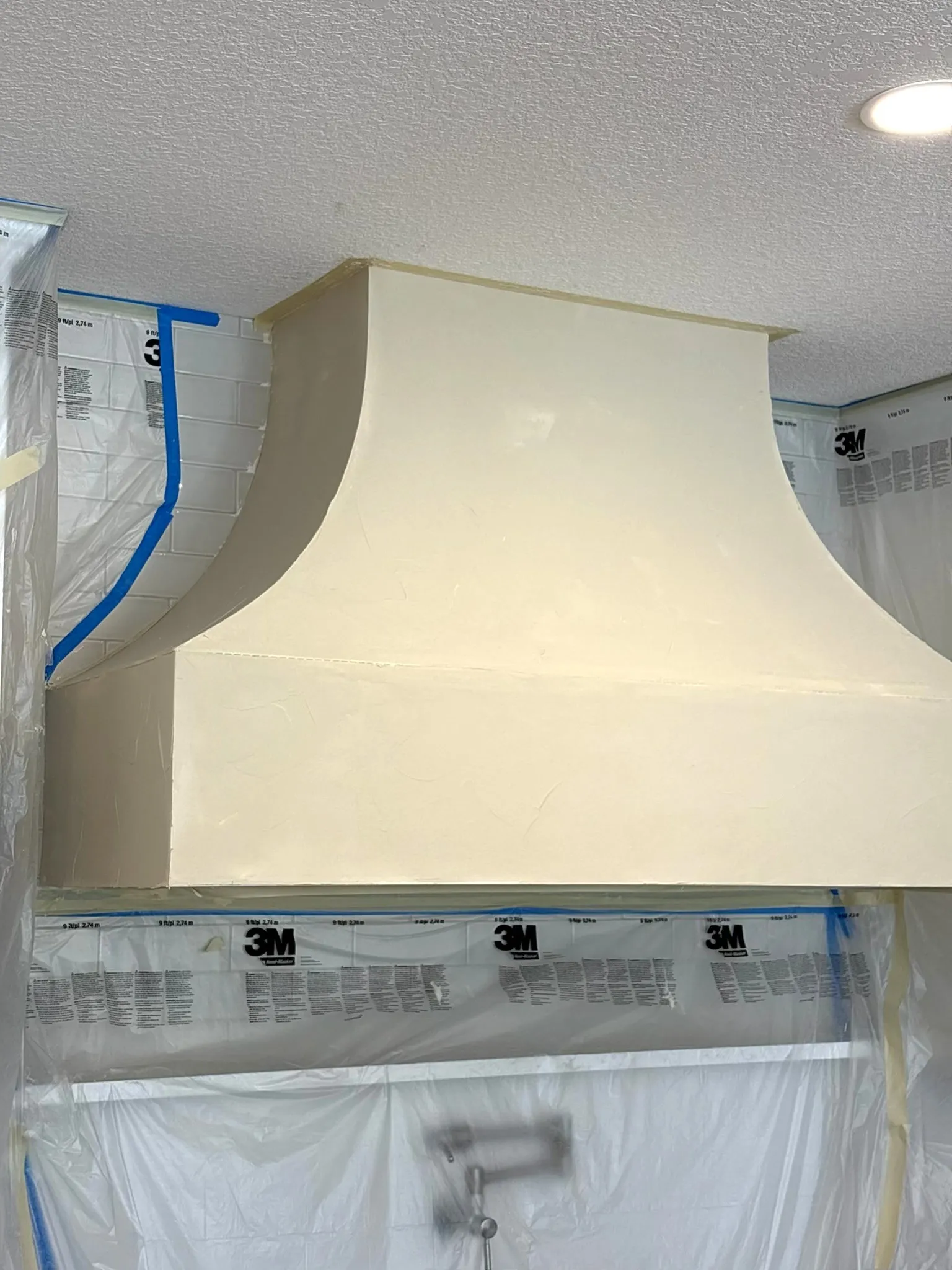 Custom range hood with fresco harmony decorative finish being applied by AvilaCo crew