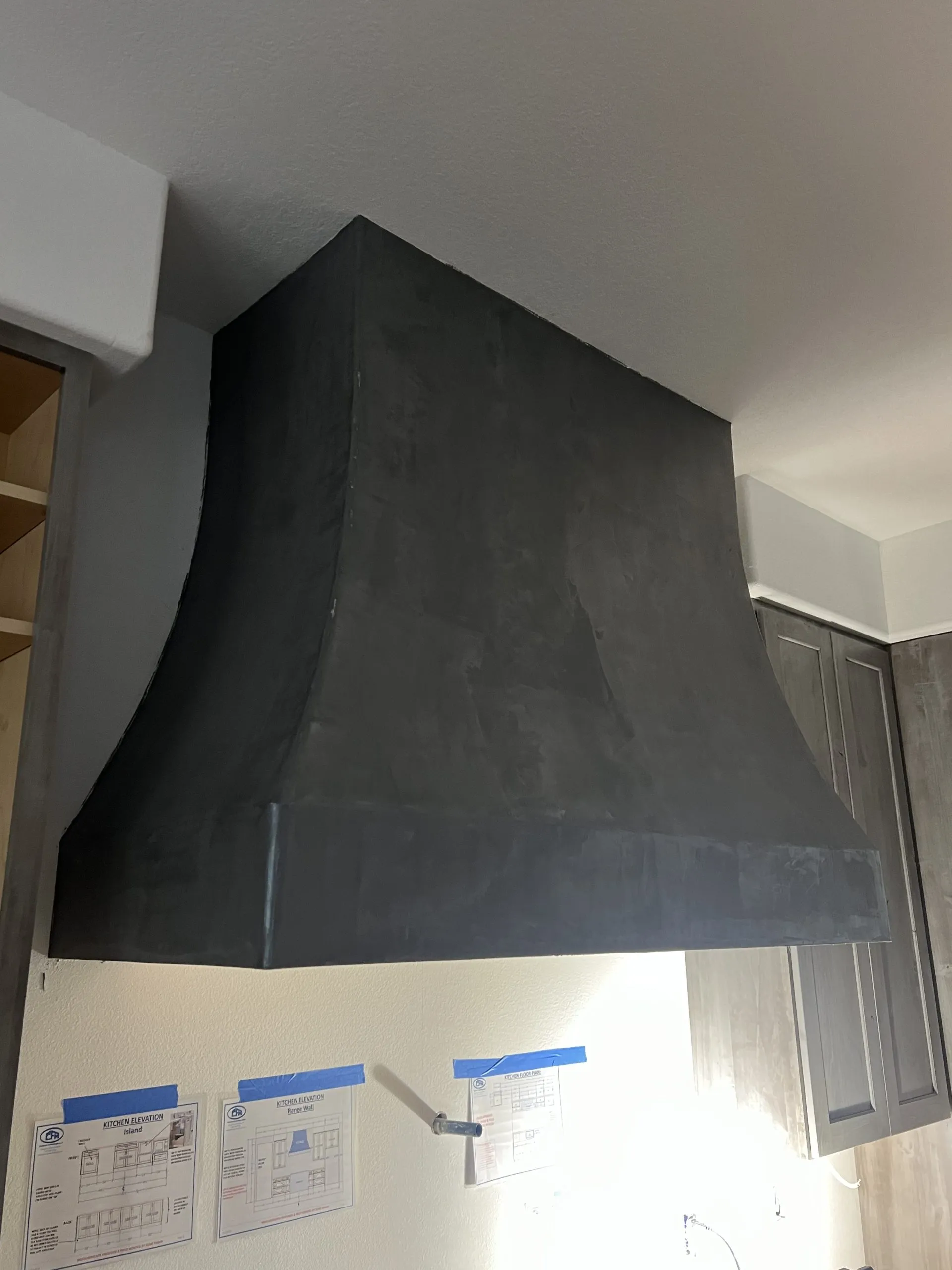Custom drywall range hood enclosure with venetian plaster finish