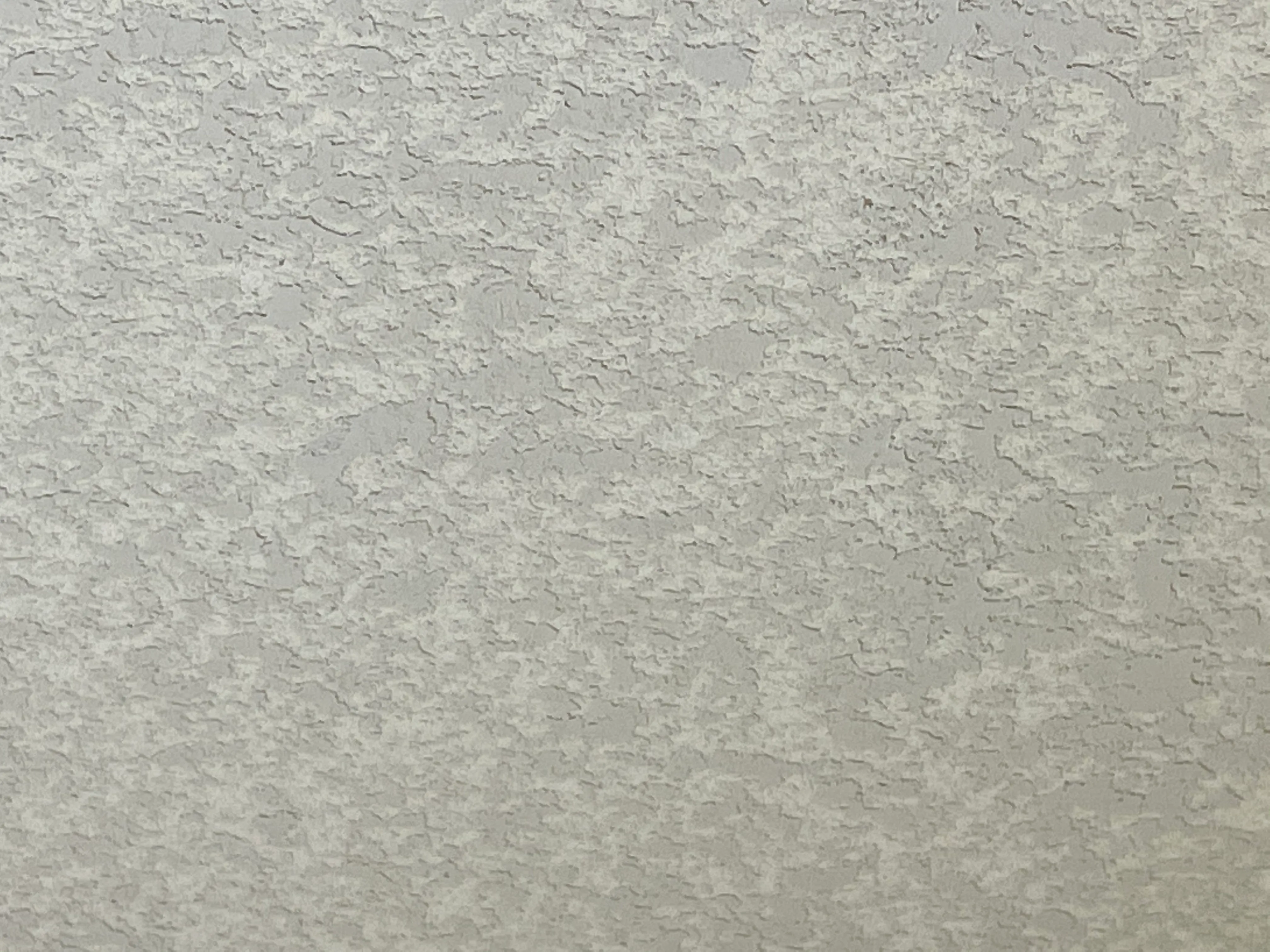 Closeup of knockdown wall texture showing the flattened splatter pattern on a finished wall