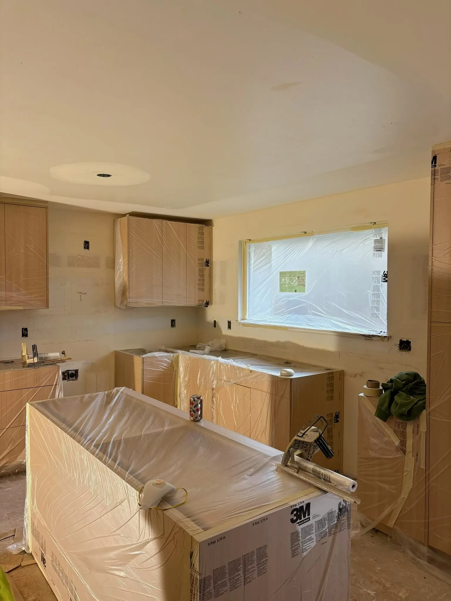 Kitchen remodel drywall work with cabinets protected during installation