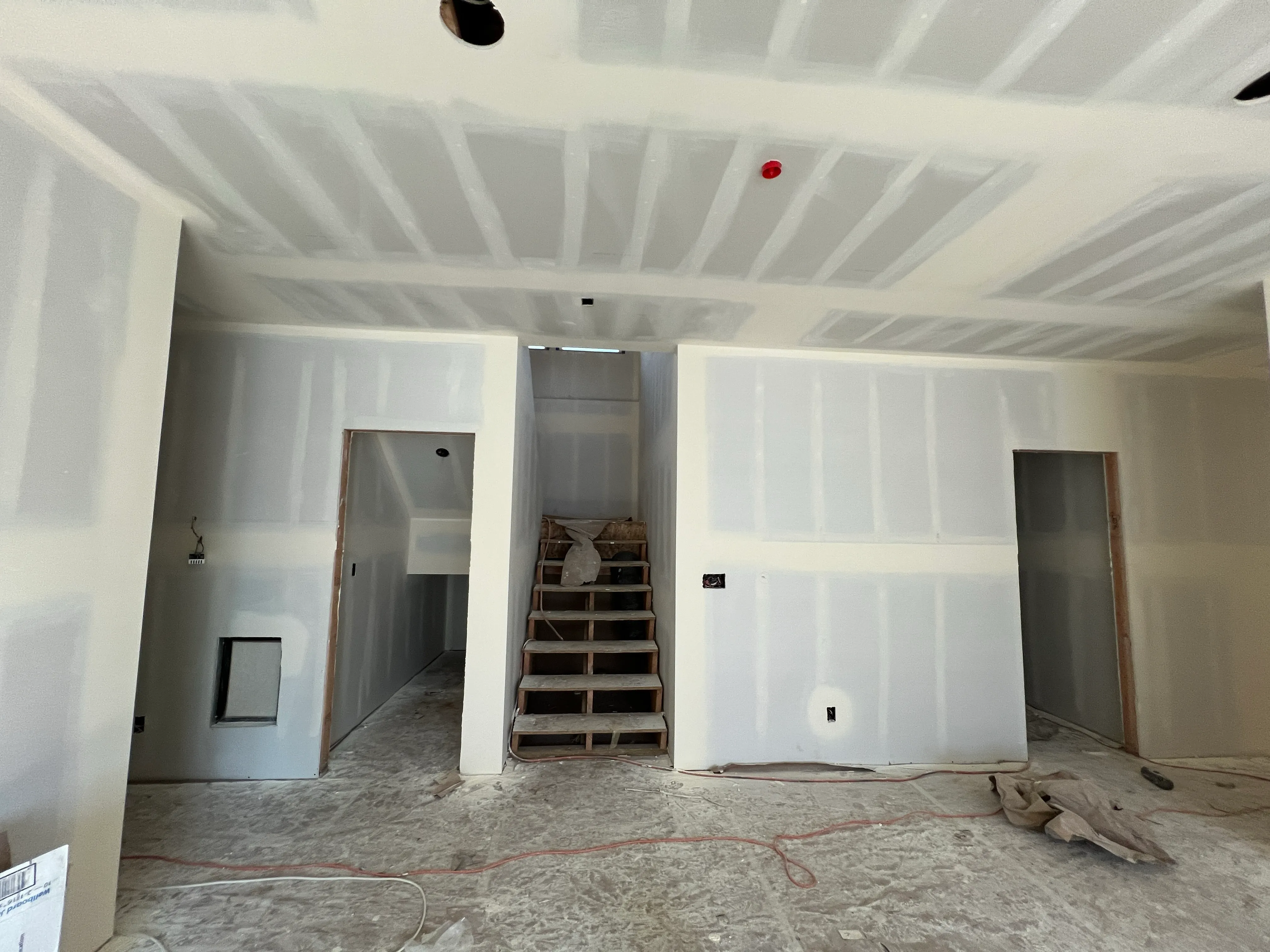 New construction drywall installation showing stairway and multi-room framing by AvilaCo Drywall