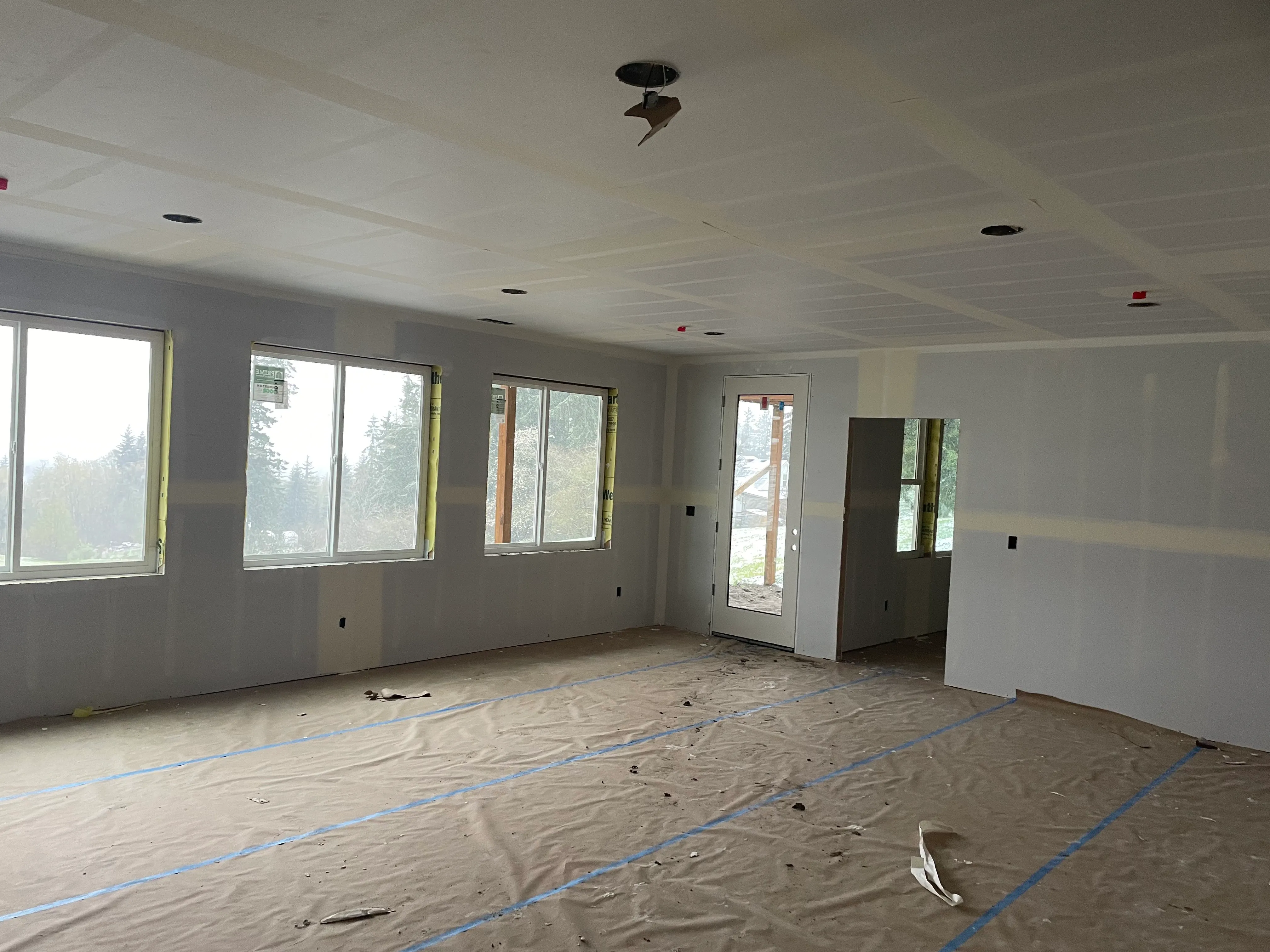 Open living area with freshly hung drywall