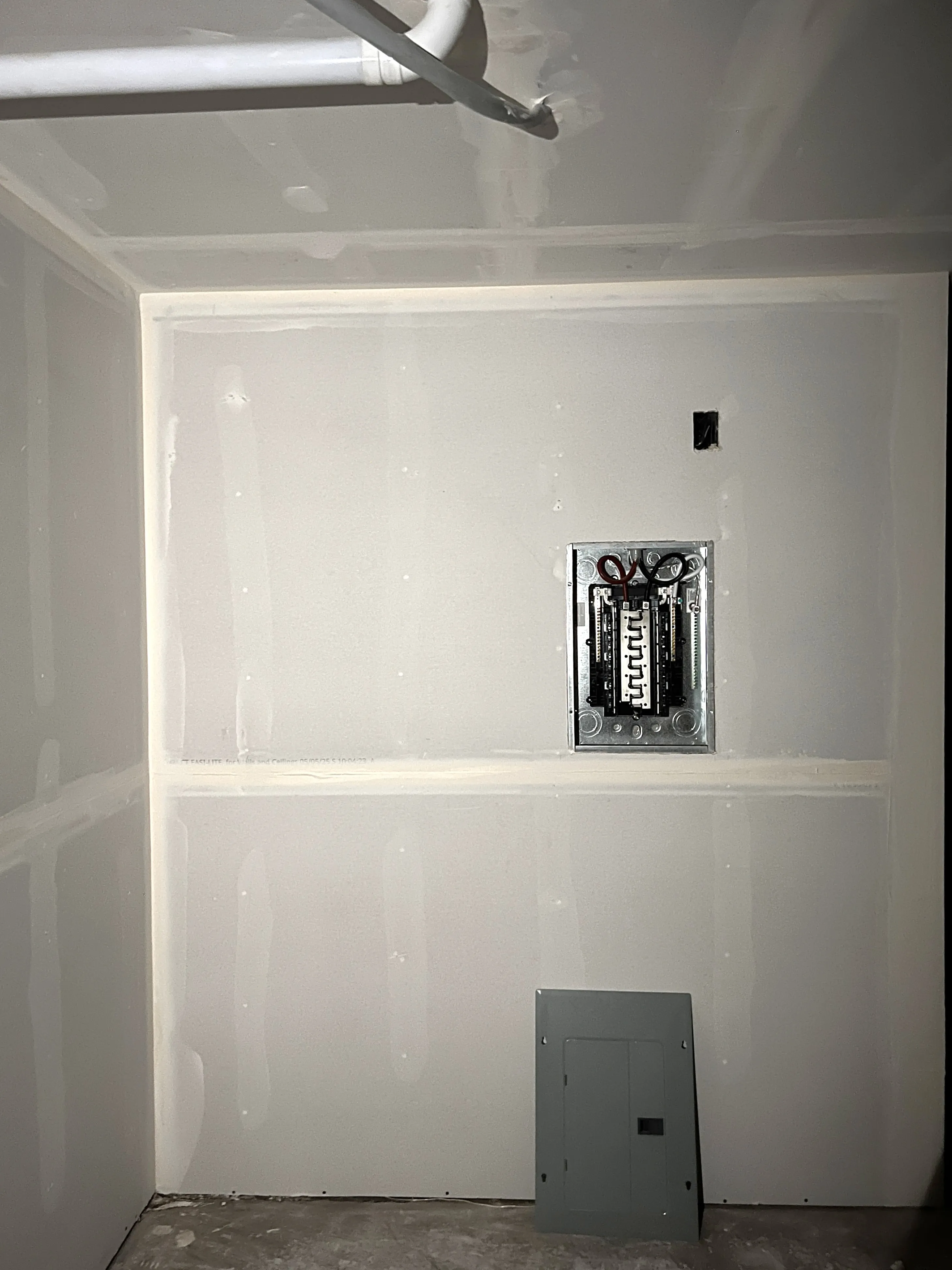 Utility room drywall installation with electrical panel cutout