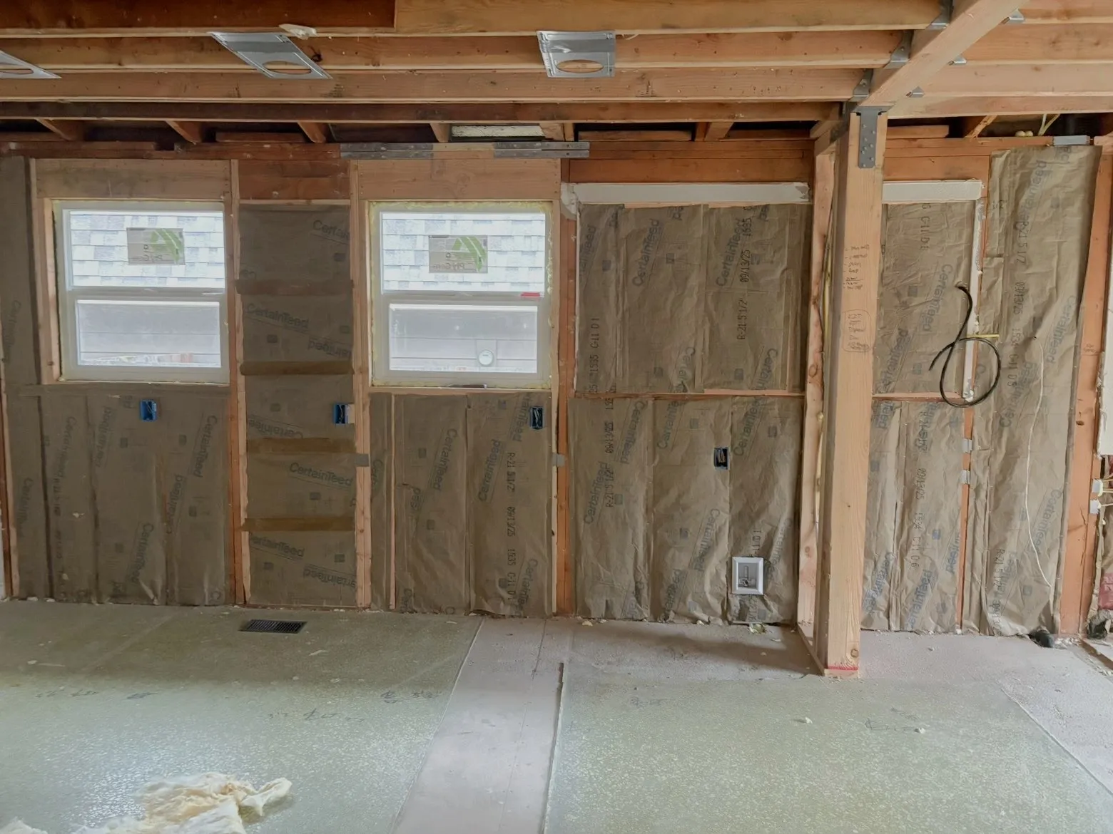 Wall insulation installation in new construction project with framing exposed